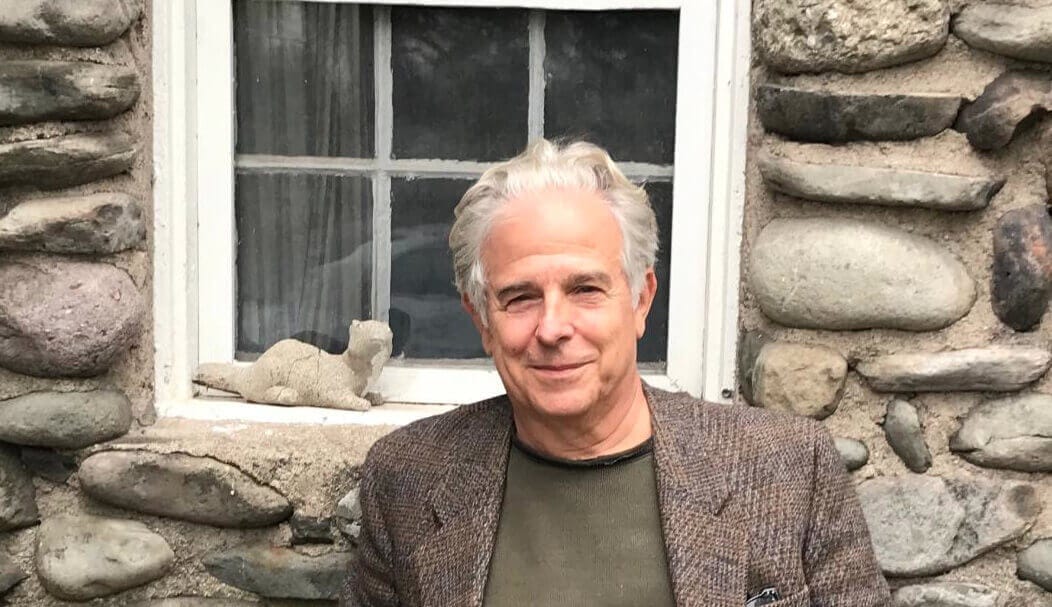 Neil Cohen in front of a stone house